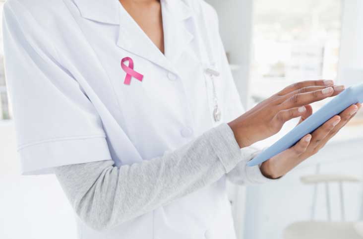 Female doctor wearing pink breast cancer awareness ribbon