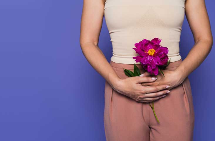 Woman standing up holding colourful blooming flowers as a menopause concept