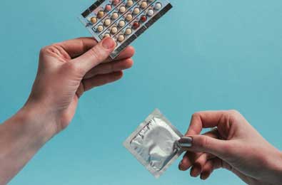 Contraceptive choice as woman decides between contraception pills or condom for sexual health